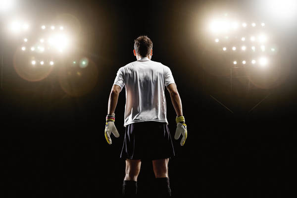 sb10068699j-002 Goalkeeper looking at stadium light, rear view