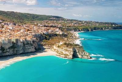 Panoramic Aerial view of Tropea coastline, monastery and public beach in summer - Italy